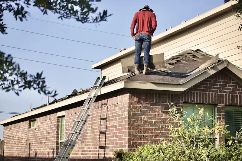 Professional roofer working on a residential roof in Mann